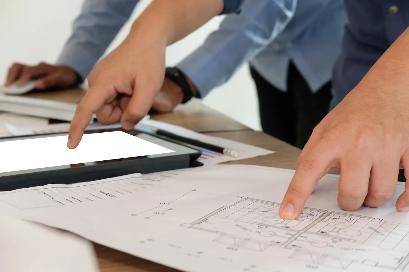 Floor plans and a tablet being reviewed while planning a remodel